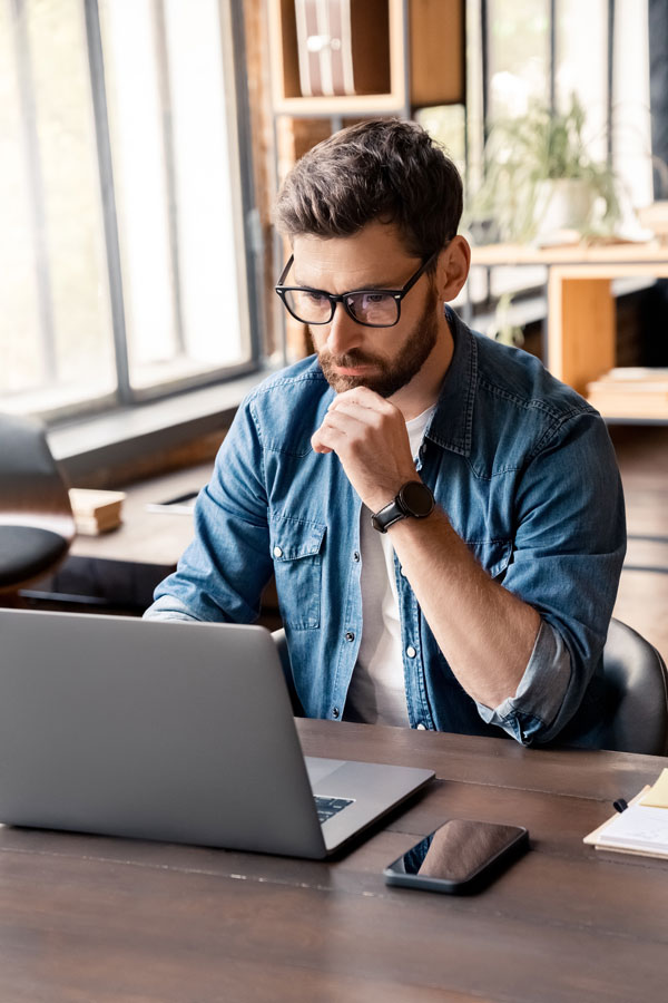 Middle aged menu at desk searching on computer